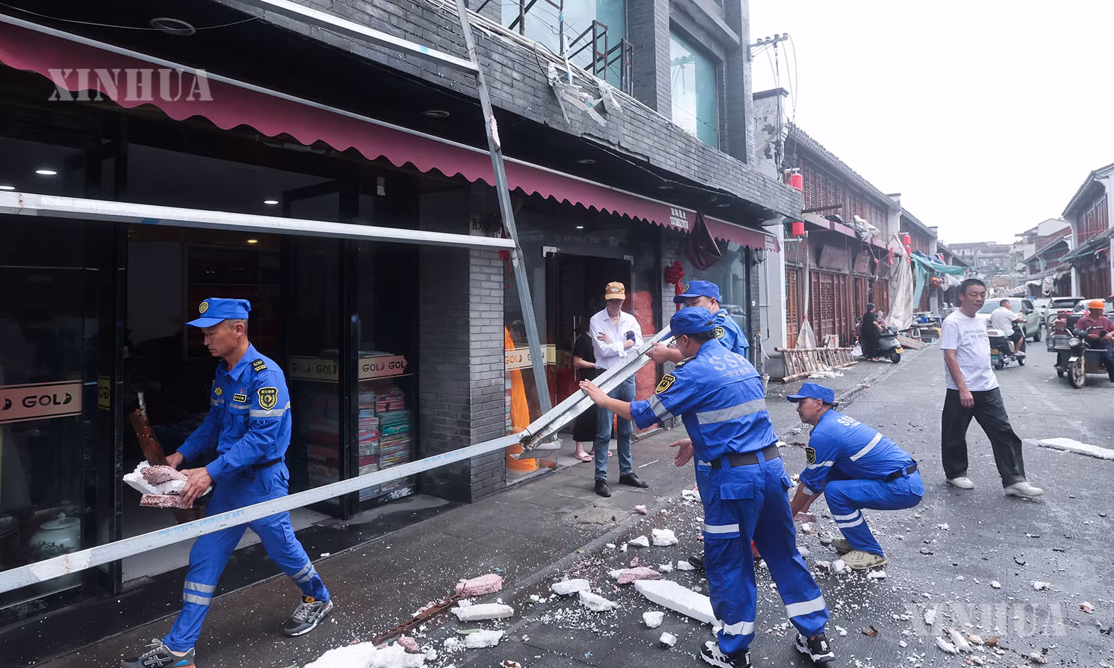 တရုတ်နိုင်ငံ ကျဲ့ကျန်းပြည်နယ်၊ ထိုင်ကျိုးမြို့၊ ယွိဟွမ်မြို့၊ ချူမန်မြို့နယ် လမ်းမထက်တွင် လေတိုက်၍ ပြိုကျသွားသော ဆိုင်းဘုတ်သံမဏိဘောင်ကို အရေးပေါ်တုံ့ပြန်ရေးသမားများက ရှင်းလင်းနေကြသည်ကို ၂၀၂၆ ခုနှစ် ဇူလိုင် ၁၂ ရက်က တွေ့ရစဉ် (ဆင်ဟွာ)