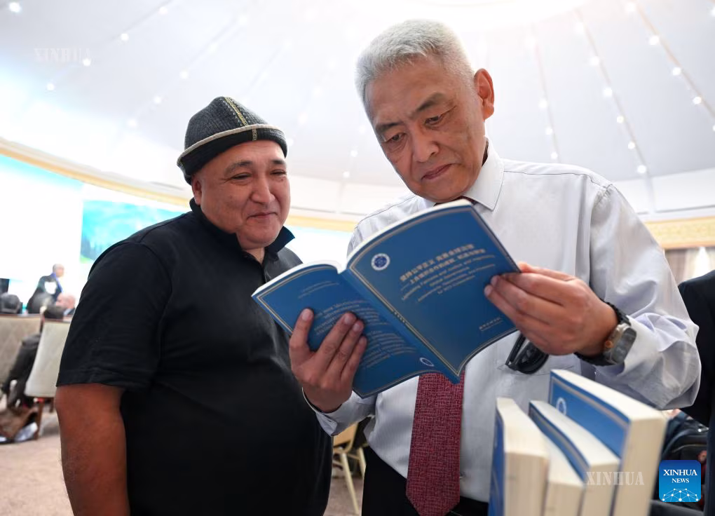 ကာဂျစ္စတန်နိုင်ငံ ဘစ်ရှ်ကက်မြို့တွင် ကျင်းပသော ၂၀၂၆ ခုနှစ် ရှန်ဟိုင်းပူးပေါင်းဆောင်ရွက်မှုအဖွဲ့ (SCO) မီဒီယာနှင့် Think Tank ထိပ်သီးအစည်းအဝေး၌ သမာသမတ်ကျမှုနှင့် တရားမျှတမှုကို လက်ကိုင်ထားကာ ကမ္ဘာလုံးဆိုင်ရာ စီမံခန့်ခွဲမှုကို ကောင်းမွန်ပြည့်စုံအောင် လုပ်ဆောင်ခြင်း၊ SCO ပူးပေါင်းဆောင်ရွက်မှုအတွက် တိုးတက်ဖြစ်ထွန်းမှုများ၊ အခွင့်အလမ်းများနှင့် အလားအလာများဟု အမည်ပေးထားသော ဆင်ဟွာ Think Tank အစီရင်ခံစာမိတ္တူအား အခမ်းအနား တက်ရောက်သူများ ဖတ်ရှုနေပုံကို ၂၀၂၆ ခုနှစ် ဇူလိုင် ၂၇ ရက်က တွေ့ရစဉ် (ဆင်ဟွာ)