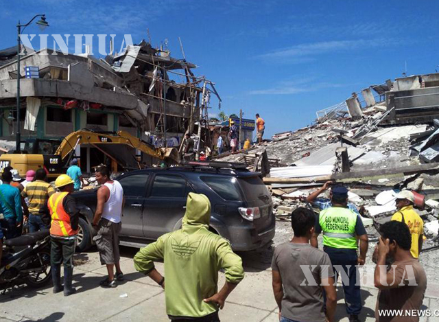 ငလျင်ကြောင့် ပြိုကျပျက်စီးသွားသော အဆောက်အအုံ ရှေ့တွင် ကယ်ဆယ်ရေးလုပ်သားများအားတွေ့ရစဉ် ( ဆင်ဟွာ )
