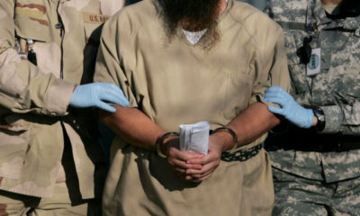 ဂွာတီနာမို အကျဉ်းထောင်မှ အကျဉ်းသား တစ်ဦးအား အကျဉ်းထောင် လုံခြုံရေးဝန်ထမ်း နှစ်ဦးက ခေါ်ဆောင်လာစဉ် (ဓာတ်ပုံ- အင်တာနက်)