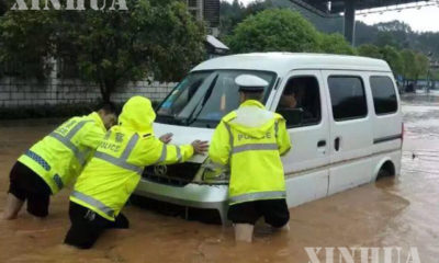 တရုတ်နိုင်ငံ တွင်မိုးသည်းထန်စွာ ရွာသွန်းမှုကြောင့် စက်ရပ်သွားသည့် ကားတစ်စီးအား ရဲများ က အကူအညီပေးနေစဉ်- (ဓါတ်ပုံ-ဆင်ဟွာ)