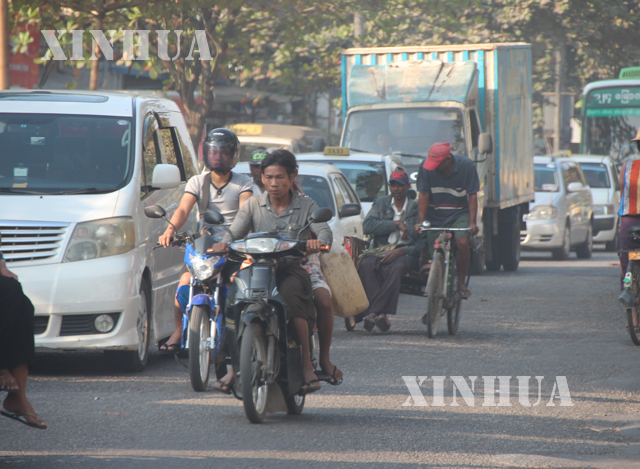 ရန်ကုန်မြို့တွင်း ဆိုင်ကယ်စီးနေသူများကို တွေ့ရစဉ် (ဆင်ဟွာ)