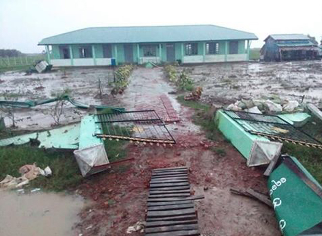 သုံးခွမြို့နယ် ရေခလာကျေးရွာ၌ လေပြင်းတိုက်ခတ်မှုကြောင့် ကျောင်းခြံစည်းရိုးများ ပြိုကျနေစဉ် (ဓာတ်ပုံ-MOI)