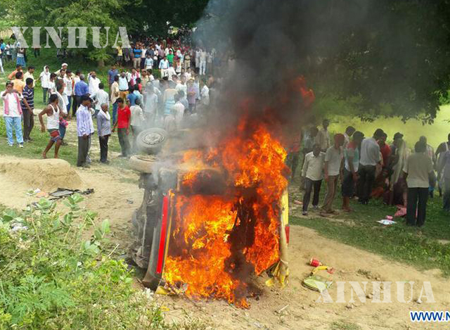 ရထားတိုက်ခံရပြီးနောက် မီးလောင် ပျက်စီးနေသော ကျောင်းကားကို တွေ့ရစဉ် (ဆင်ဟွာ)