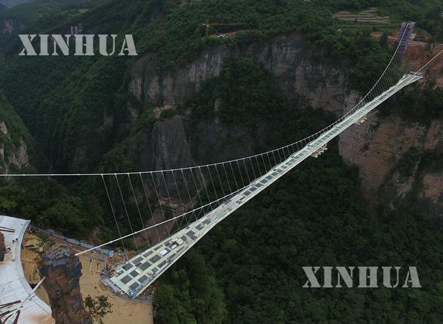 တရုတ်နိုင်ငံရှိ ကမ္ဘာ့အရှည်ဆုံး နှင့် အမြင့်ဆုံး ဖန်တံတားအား တည်ဆောက်နေစဉ် မြင်ကွင်းအား တွေ့ရစဉ် (ဆင်ဟွာ)