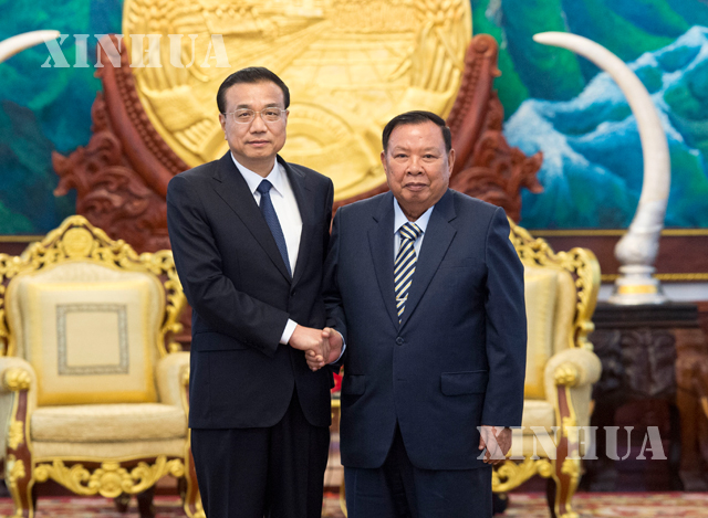 တရုတ်နိုင်ငံ ဝန်ကြီးချုပ် လီခဲ့ချန် နှင့် လာအိုနိုင်ငံ သမ္မတ ဘွန်ညံ ဗိုရာချစ် တို့ လက်ဆွဲနှုတ်ဆက်နေစဉ် (ဆင်ဟွာ)