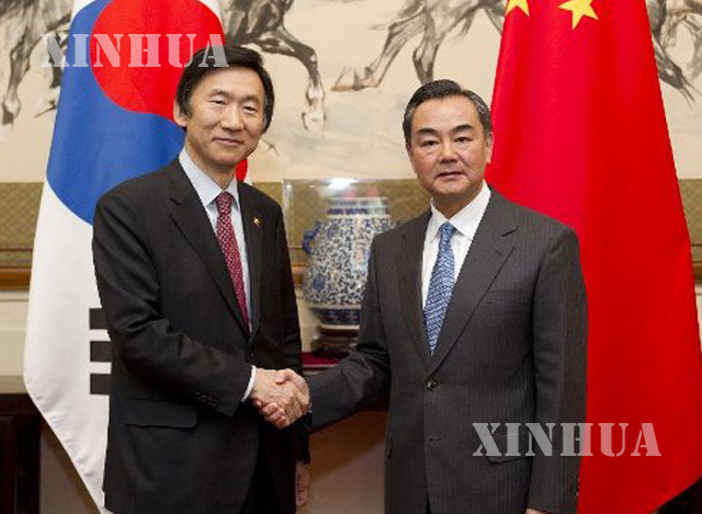 တရုတ်နိုင်ငံခြားရေးဝန်ကြီး ဝန်ရိ နှင့်တောင်ကိုရီးယားနိုင်ငံခြားရေးဝန်ကြီး Yun Byung-se တို့လက်ဆွဲနှုတ်ဆက်နေစဉ်(ဆင်ဟွာ)