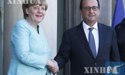 ပြင်သစ်သမ္မတ ဖရန်ဆွာ ဟော်လန်ဒီ နှင့် ဂျာမနီဝန်ကြီးချုပ် အန်ဂျလာ မာကယ် တို့ လက်ဆွဲနှုတ်ဆက်နေစဉ် (ဆင်ဟွာ)
