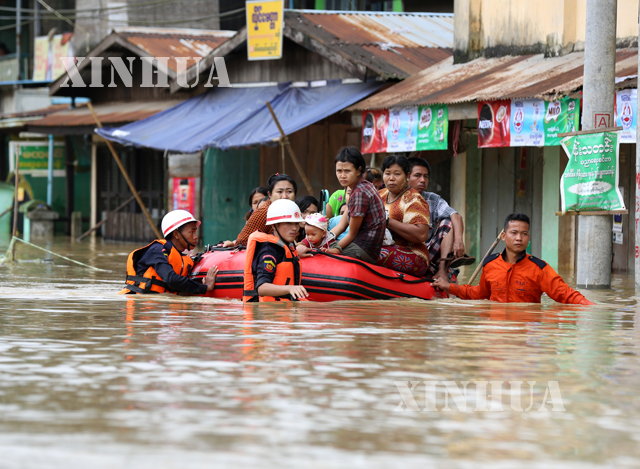 မိုးသည္းထန္စြာရြာသြန္းၿပီး ေရႀကီးေရလွ်ံမႈေၾကာင့္ ေရေဘးသင့္ သူမ်ားကို ကယ္ဆယ္ေရးျပဳလုပ္ေနစဥ္(ဆင္ဟြာ)