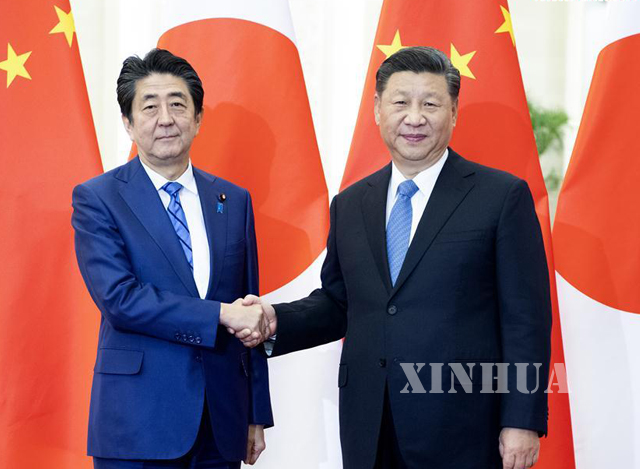 တရုတ်နိုင်ငံသမ္မတရှီကျင့်ဖိန် နှင့် ဂျပန်နိုင်ငံဝန်ကြီးချုပ်ရှင်ဇိုအာဘေး တို့ ပေကျင်းမြို့၌ ဒီဇင်ဘာ ၂၃ ရက်က လက်ဆွဲနှုတ်ဆက်စဉ်(ဆင်ဟွာ)