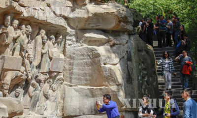 တရုတ်နိုင်ငံအနောက်တောင်ပိုင်း ချုံချင့်မြူနီစီပယ်ဒေသရှိ Dazu ကျောက်သားပန်းပုလက်ရာများသို့ ခရီးသွားများ လာရောက်လေ့လာနေကြစဉ် (ဆင်ဟွာ)