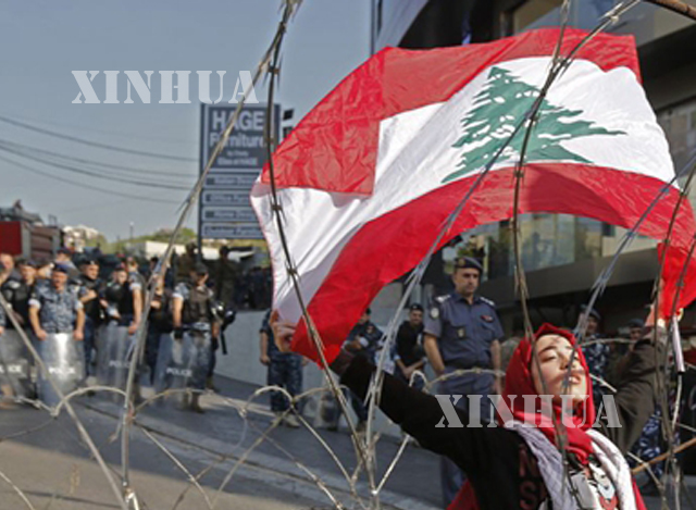လက်ဘနွန် နိုင်ငံ အလံကို ကိုင်ဆောင် ဆန္ဒပြသူ တစ်ဉီးအား နိုဝင်ဘာလ အတွင်းက တွေ့ရစဉ်(ဆင်ဟွာ)