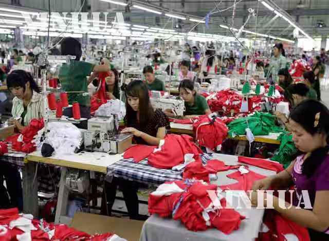 အထည်ချုပ်လုပ်ငန်းခွင်တွင် လုပ်သားများ အလုပ်လုပ်ကိုင်နေစဉ် (ဆင်ဟွာ)