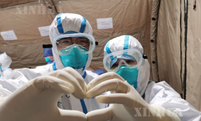 တရုတ်နိုင်ငံ ဝူဟန့်ဆေးရုံရှိ ကိုရိုနာဗိုင်းရပ် ကုသရေးအဆောင်တစ်ခုတွင် ဆေးဝန်ထမ်းနှစ်ဦး လက်ချောင်းချင်းကပ်၍ အသဲပုံသဏ္ဍာန် ဓာတ်ပုံရိုက်ကူးနေစဉ်(ဆင်ဟွာ)