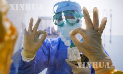 တရုတ်နိုင်ငံ အရှေ့တောင်ပိုင်း ဖူကျင့်ပြည်နယ်ရှိ Zhangzhou ဆေးရုံ၌ မှန်တစ်ဖက်တစ်ချပ်ဆီမှနေ၍ ဝန်ထမ်းနှစ်ဦး အပြန်အလှန်နှုတ်ဆက်စဉ်(ဆင်ဟွာ)
