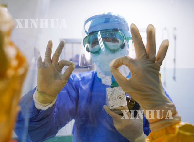 တရုတ်နိုင်ငံ အရှေ့တောင်ပိုင်း ဖူကျင့်ပြည်နယ်ရှိ Zhangzhou ဆေးရုံ၌ မှန်တစ်ဖက်တစ်ချပ်ဆီမှနေ၍ ဝန်ထမ်းနှစ်ဦး အပြန်အလှန်နှုတ်ဆက်စဉ်(ဆင်ဟွာ)
