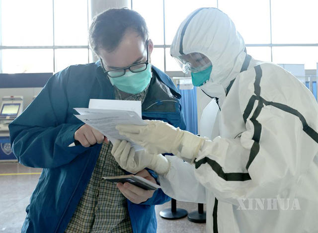 တရုတ်နိုင်ငံ ပေကျင်းမြို့ရှိ နိုင်ငံတကာလေဆိပ်တွင် အကောက်ခွန်အရာရှိတစ်ဦးက ခရီးသည်တစ်ဦး၏ ကျန်းမာရေးလက်မှတ်အားစစ်ဆေးနေစဉ်(ဆင်ဟွာ)