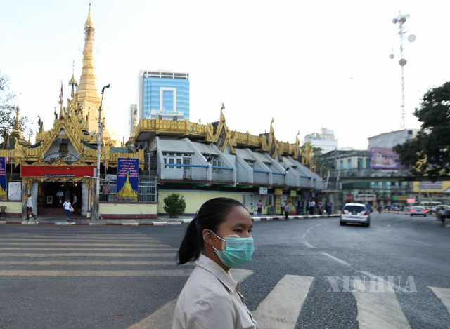 ရန်ကုန်မြို့လယ်၌ နှာခေါင်းစည်းတပ်၍ သွားလာသူ တစ်ဦးအား တွေ့ရစဉ်(ဆင်ဟွာ)