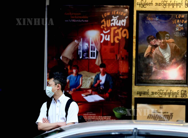 ရန်ကုန်မြို့ရှိ ရုပ်ရှင်ရုံ တစ်ရုံရှေ့တွင် နှာခေါင်းစည်း တပ်ဆင်ထားသူ တစ်ဦးအား တွေ့ရစဉ်(ဆင်ဟွာ)