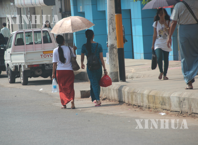 ရန်ကုန်မြို့တွင် နေအပူဒဏ် ကိုကာကွယ်ရန် ထီးဖြင့် သွားလာကြသူတစ်ချို့ အားတွေ့ရစဉ် (ဆင်ဟွာ)