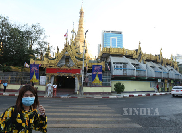 ရန်ကုန်မြို့၌ နှာခေါင်းစည်း တပ်ဆင်သွားလာနေသူ အမျိုးသမီး တစ်ဦးအား တွေ့ရစဉ်(ဆင်ဟွာ)