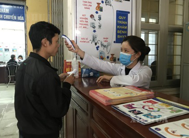 ဗီယက်နမ် နိုင်ငံ ဟနွိုင်းမြို့ရှိ ဆေးရုံ၌ ကျန်းမာရေး စစ်ဆေးရန် လာရောက်သူ တစ်ဦးအား ကိုယ်ပူချိန် တိုင်းတာနေမှုအား မတ် ၉ ရက်က တွေ့ရစဉ်(ဆင်ဟွာ)