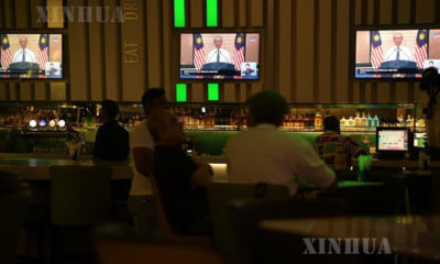 မလေးရှားနိုင်ငံ ကွာလာလမ်ပူမြို့ရှိ စားသောက်ဆိုင် တစ်ခုတွင် မတ် ၁၆ ရက်က တီဗွီမှ ထုတ်လွှင့်သော ဝန်ကြီးချုပ်မိန့်ခွန်းအား ကြည့်ရှုနားထောင်နေသူများအား တွေ့ရစဉ်(ဆင်ဟွာ)