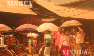 နွေရာသီတွင် ထီးဖြင့်သွားလာနေကြသူတစ်ချို့အားတွေ့ရစဉ် (ဆင်ဟွာ)