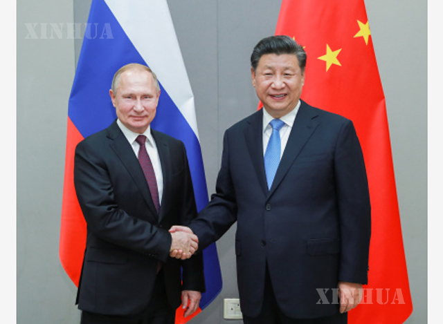 တရုတ် နိုင်ငံ သမ္မတ ရှီကျင့်ဖိန် နှင့် ရုရှား နိုင်ငံ သမ္မတ ဗလာဒီမာပူတင် (Vladimir Putin) တို့ လက်ဆွဲနှုတ်ဆက်နေစဉ်(ဆင်ဟွာ)