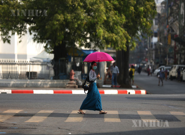 ရန်ကုန်မြို့တွင် နှာခေါင်းစည်းတပ်ဆင် သွားလာနေသူတစ်ဦးအားတွေ့ရစဉ်(ဆင်ဟွာ)
