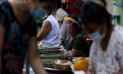 နှာခေါင်းစည်းနှင့် ဈေးရောင်းနေသူ အားတွေ့ရစဉ် (ဆင်ဟွာ)