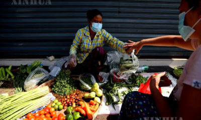 ရန်ကုန်မြို့၌ နှာခေါင်းစည်း တပ်ဆင်၍ ဈေးရောင်းနေသူ တစ်ဦးအား တွေ့ရစဉ်(ဆင်ဟွာ)