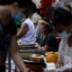 ရန်ကုန်မြို့၌ နှာခေါင်းစည်း တပ်ဆင်၍ ဈေးရောင်းချနေသူ တစ်ဦးအား တွေ့ရစဉ်(ဆင်ဟွာ)