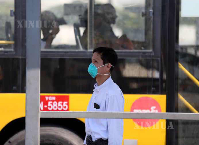 ရန်ကုန်မြို့၌ နှာခေါင်းစည်း တပ်ဆင် သွားလာသူ တစ်ဦးအား တွေ့ရစဉ်(ဆင်ဟွာ)