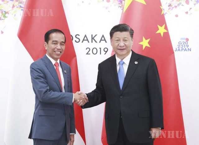 တရုတ်နိုင်ငံ သမ္မတ ရှီကျင့်ဖိန် (ယာ) နှင့် အင်ဒိုနီးရှားနိုင်ငံ သမ္မတ ဂျိုကို ဝီဒိုဒိုတို့ လက်ဆွဲနှုတ်ဆက်နေစဉ် (ဆင်ဟွာ)