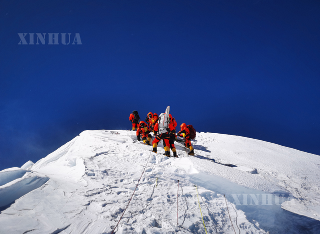 တရုတ်နိုင်ငံမြေတိုင်ပညာရှင်များ ယနေ့ မေ ၂၇ ရက်တွင် ကမ္ဘာ့အမြင့်ဆုံး ချိုမိုလန်းမား တောင်ထိပ်သို့ တက်ရောက်နေသည်ကိုတွေ့ရစဉ်(ဆင်ဟွာ)