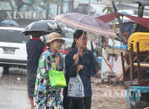 ရန်ကုန်မြို့တွင် ထီးဖြင့်သွားလာနေကြသူအချို့အားတွေ့ရစဉ် (ဆင်ဟွာ)