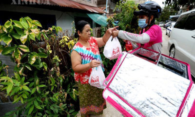 ရန်ကုန်မြို့တွင်း အစားအသောက်များအား စက်ဘီးစီးနင်း၍ လိုက်လံပို့ဆောင်ပေးနေသော မခင်မင်းသျှင်အား တွေ့ရစဉ်(ဆင်ဟွာ)