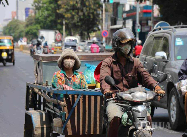 ကမ္ဘောဒီးယားနိုင်ငံ ဖနွမ်းပင်မြို့ရှိ လမ်းမတစ်နေရာတွင် နှာခေါင်းစည်းများဝတ်ဆင်၍ သွားလာနေသူများကို တွေ့ရစဉ် (ဆင်ဟွာ)