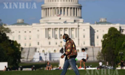 အမေရိကန်နိုင်ငံ ဝါရှင်တန်ဒီစီရှိ U.S. Capitol အဆောက်အဦအနီး နှာခေါင်းစည်းဝတ်ထားသော အမျိုးသားတစ်ဦး လမ်းလျှောက်နေသည်ကို တွေ့ရစဉ် (ဆင်ဟွာ)