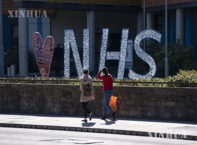 ဗြိတိန်နိုင်ငံ မန်ချက်စတာမြို့ Salford Royal ဆေးရုံ အပြင်ဘက်ရှိ Love NHS(National Health Service)သင်္ကေတရှေ့မှ ဖြတ်သန်းသွားလာကြသူများအား တွေ့ရစဉ်(ဆင်ဟွာ)