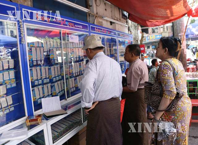 ရန်ကုန်မြို့ရှိ အောင်ဘာလေ ထီအရောင်းဆိုင် တစ်ခုတွင် ထီထိုးနေသူများအား တွေ့ရစဉ်(ဆင်ဟွာ)