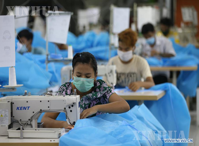 ခွဲစိတ်ခန်းသုံးဝတ်စုံများအား အထည်ချုပ် စက်ရုံ တစ်ခုမှ အလုပ်သမားများက ချုပ်လုပ်နေမှုအား မေလအတွင်းက တွေ့ရစဉ်(ဆင်ဟွာ)