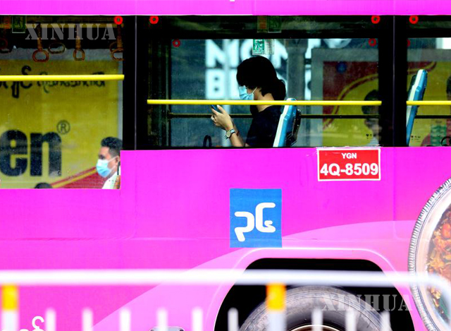 ရန်ကုန်မြို့တွင်း ပြေးဆွဲနေသော ဘတ်စ်ကားပေါ်တွင် နှာခေါင်းစည်း တပ်ဆင်၍ စီးနင်းနေသူများအား တွေ့ရစဉ်(ဆင်ဟွာ)