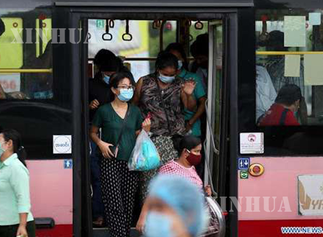 နှာခေါင်းစည်းဖြင့် ဘတ်စ်ကားပေါ်မှ ဆင်းလာသူတစ်ချို့အားတွေ့ရစဉ် (ဆင်ဟွာ)