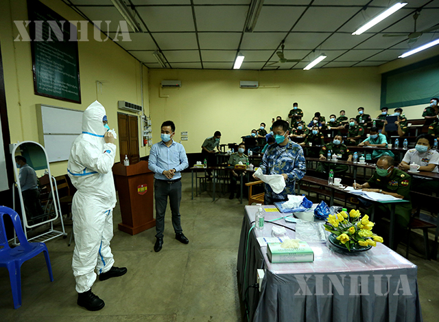 ရန်ကုန်မြို့ ရှိ ဆေးရုံ တစ်ခုတွင် တရုတ် ဆေးပညာရှင်က ကာကွယ်ရေးဝတ်စုံ ဝတ်ဆင်ပုံ ကို ပြသပေးနေစဉ် (ဆင်ဟွာ)
