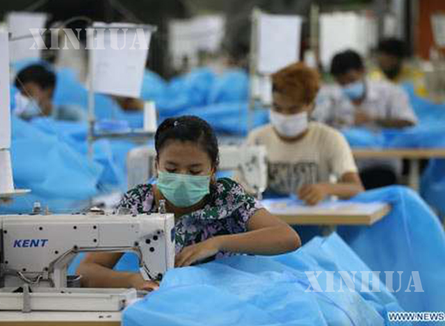 အထည်ချုပ်စက်ရုံတစ်ခုတွင် နှာခေါင်းစည်းဖြင့် အလုပ်လုပ်နေကြသူများအားတွေ့ရစဉ် (ဆင်ဟွာ)