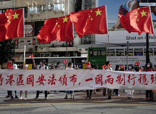 ဟောင်ကောင် အထူးအုပ်ချုပ်ခွင့်ဒေသခံများက ဇွန် ၃၀ ရက်တွင် အမျိုးသားလုံခြုံရေး ထိန်းသိမ်းစောင့်ရှောက်မှုဥပဒေ ပြဌာန်းခြင်းအား ထောက်ခံကြိုဆိုသောအားဖြင့် တရုတ်နိုင်ငံတော်အလံနှင့် ဟောင်ကောင်အလံများကို ဝှေ့ယမ်းနေကြစဉ် (ဆင်ဟွာ)