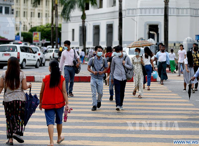 ရန်ကုန်မြို့တွင် နှာခေါင်းစည်း တပ်ဆင်၍ သွားလာနေသူများအား ဇူလိုင် ၁၀ ရက်က တွေ့ရစဉ်(ဆင်ဟွာ)