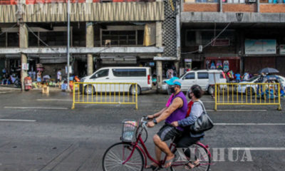 ဖိလစ်ပိုင်နိုင်ငံ မနီလာမြို့၌ နှာခေါင်းစည်း တပ်ဆင်၍ စက်ဘီးစီးနင်းသွားလာနေသူများအား တွေ့ရစဉ်(ဆင်ဟွာ)
